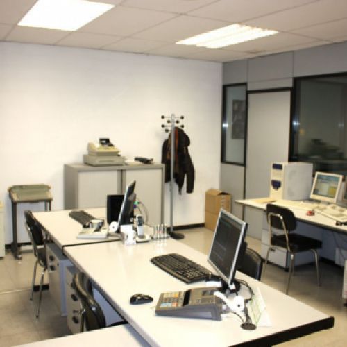 Interior d'oficina amb taules i ordinadors