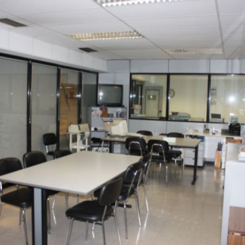 Oficina amb taules llargues i diverses cadires