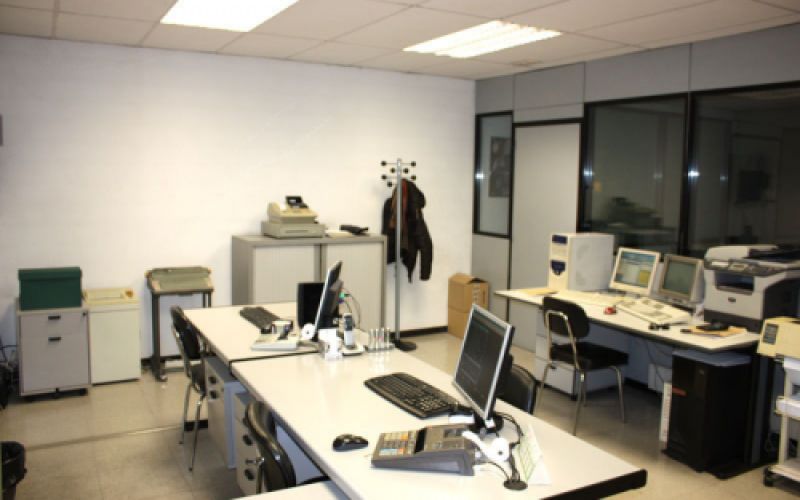 Interior d'oficina amb taules i ordinadors